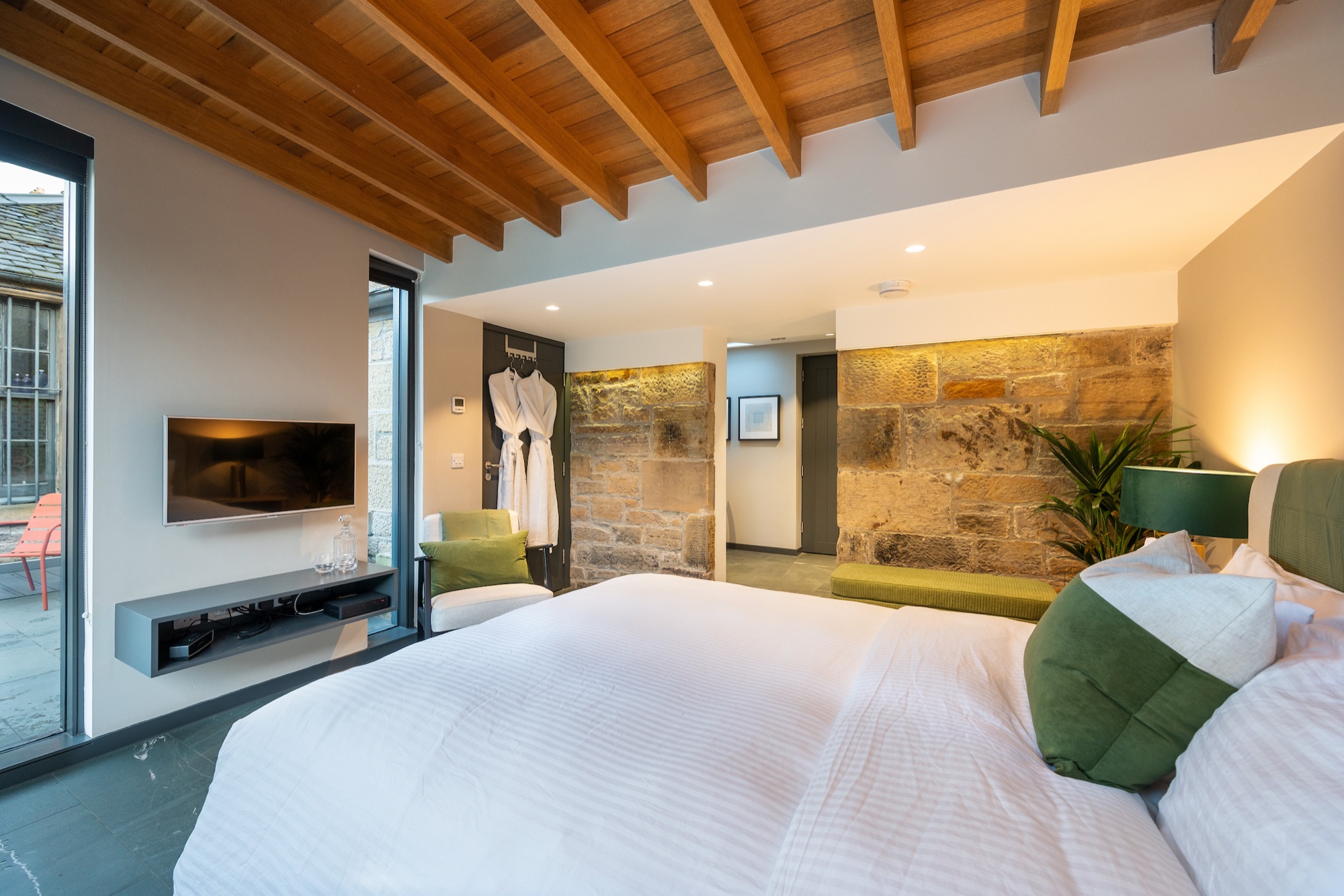 Bedroom bifold doors fully open to the walled garden