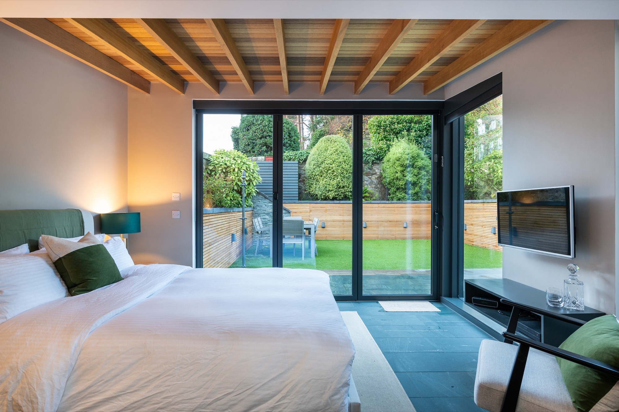 King bed with bifold doors open to garden