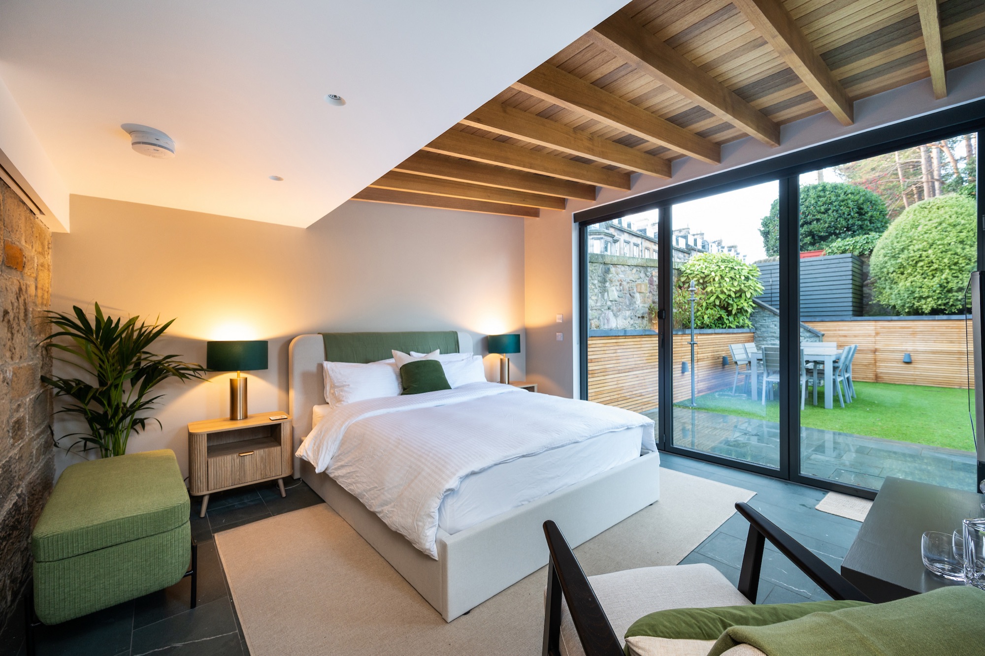 King bed with stone wall and garden view