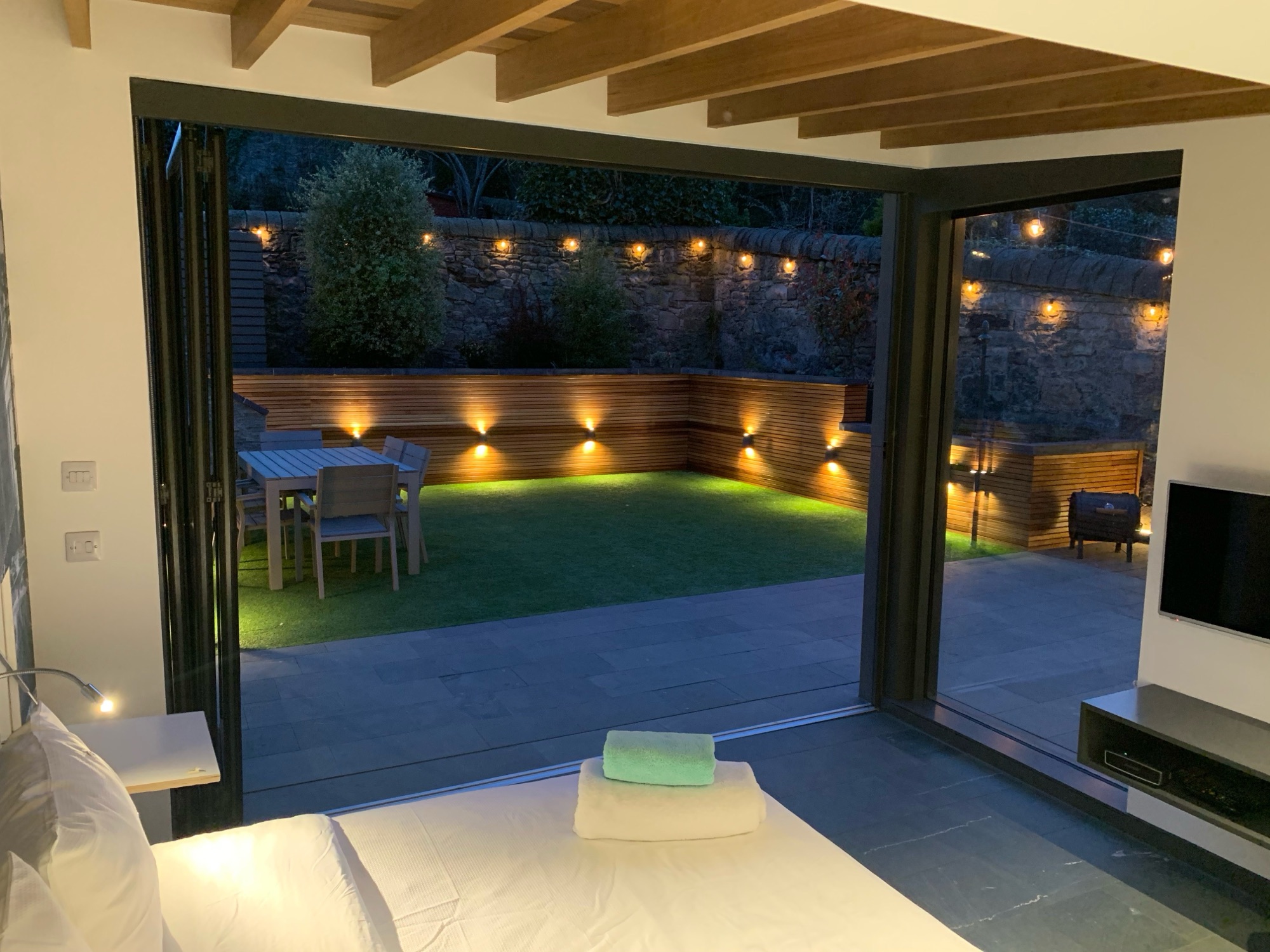 Lounge chair with garden lit up at night beyond