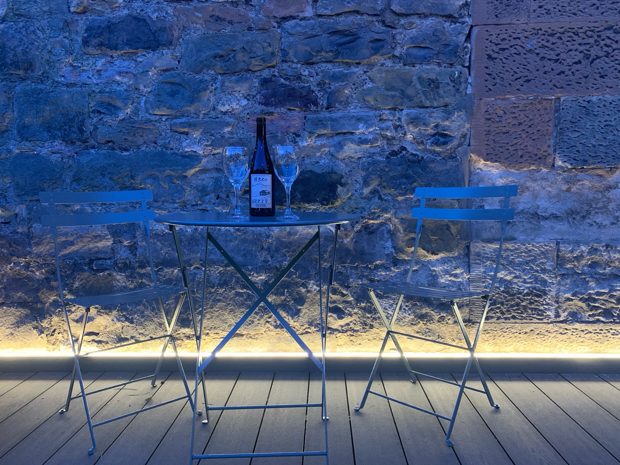 Garden bistro table with wine at night