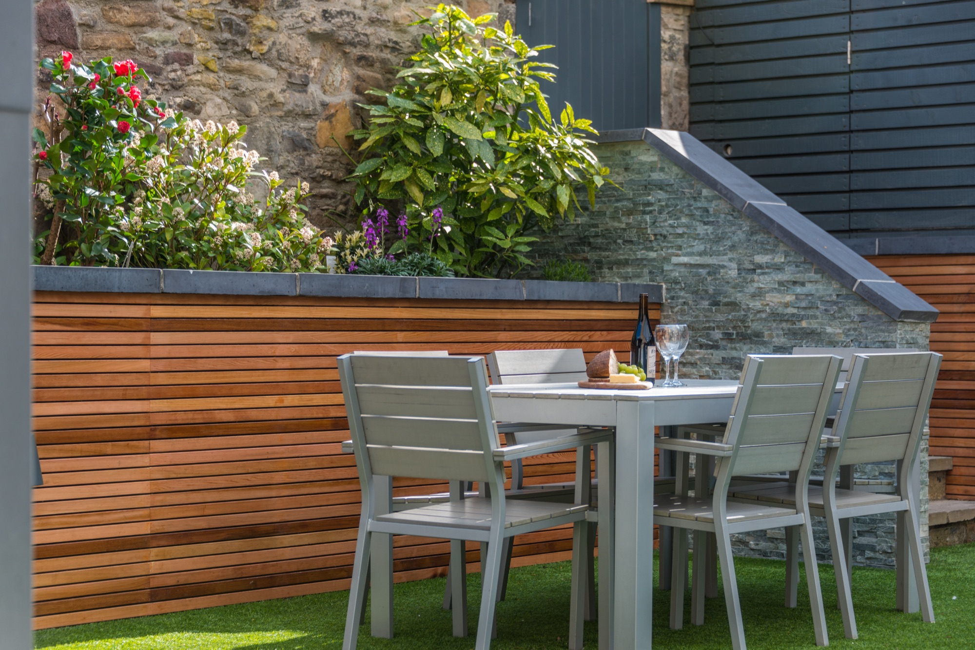 Garden dining table with wine and summer flowers