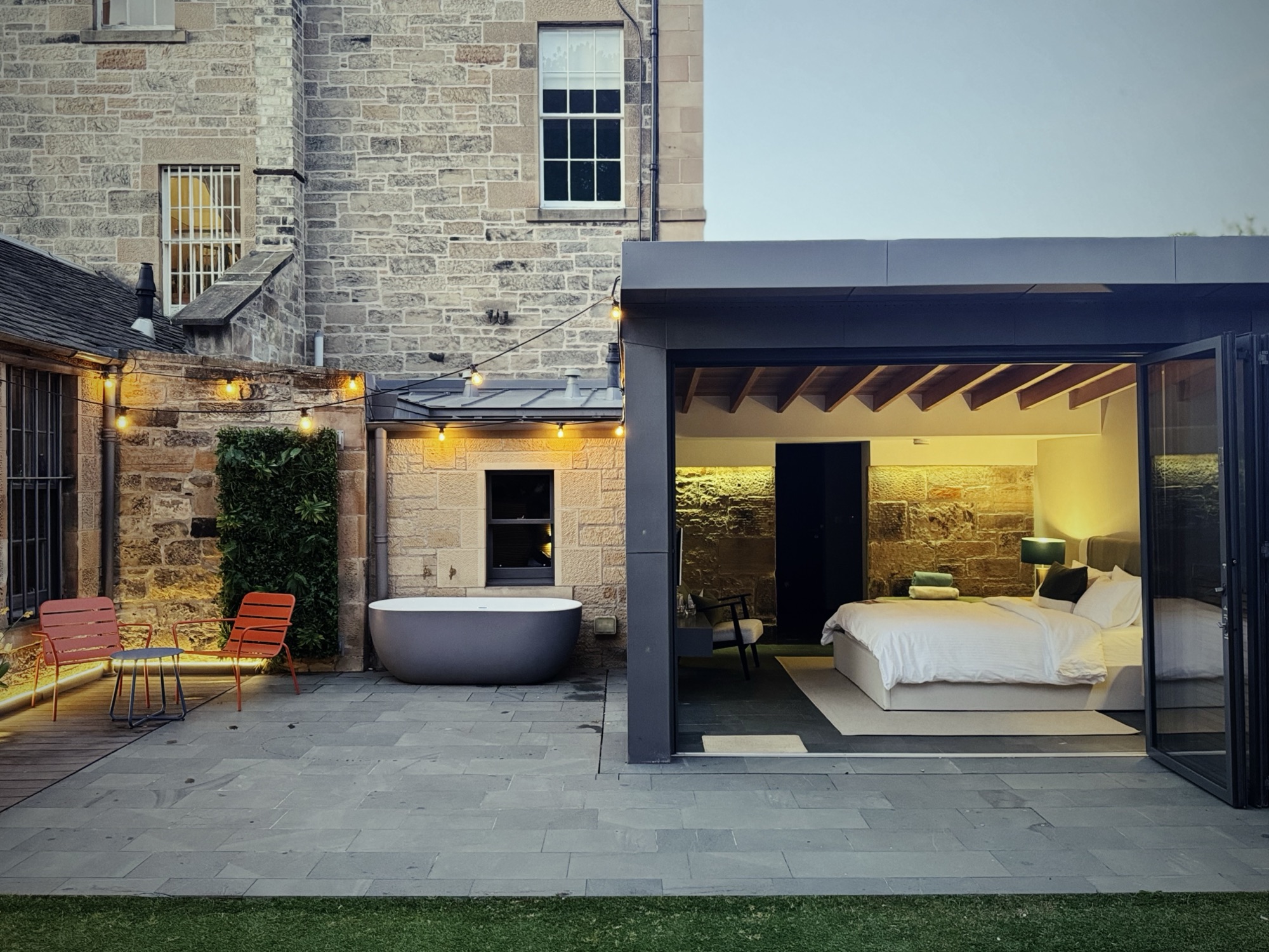 The walled garden, outdoor bath and open bedroom at dusk