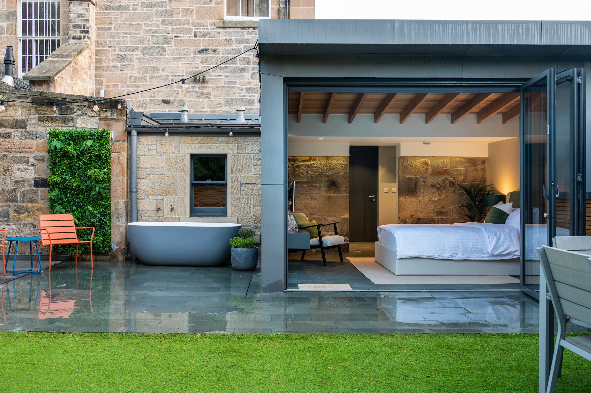 Wide garden view with bath and lit bedroom at evening