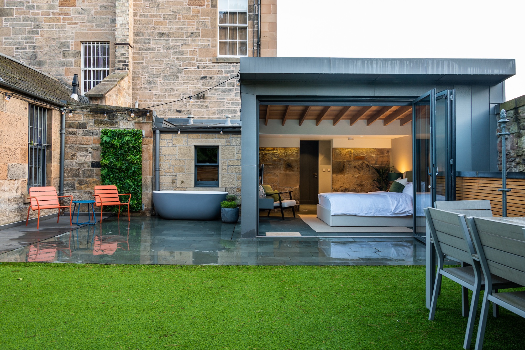 Garden and outdoor bath with bedroom glowing at dusk