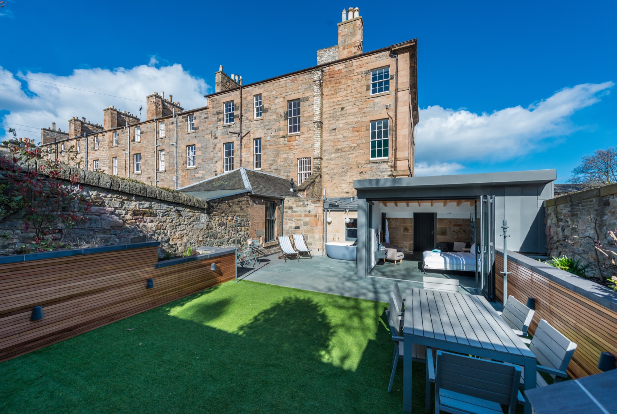 Walled garden wide view with dining area and bath